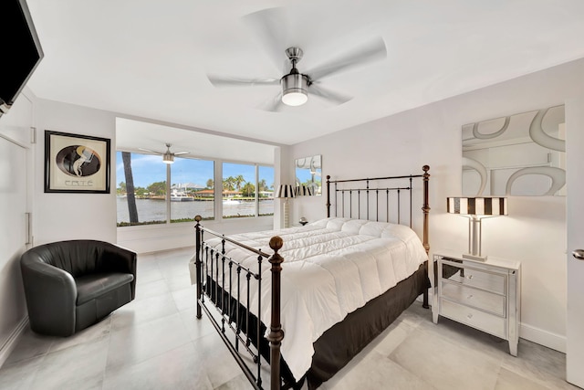 bedroom featuring ceiling fan and a water view