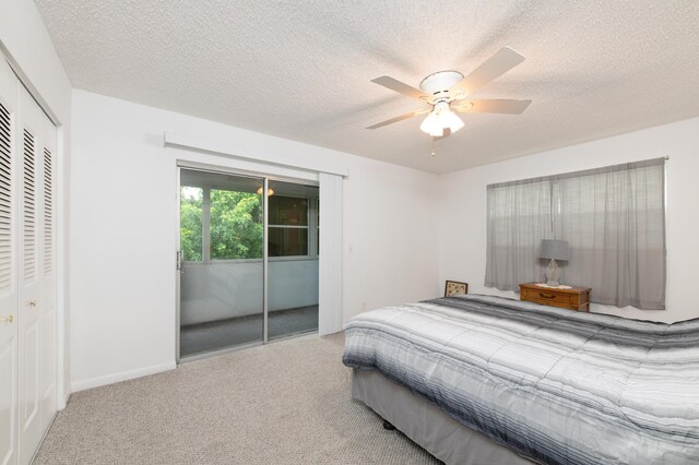 bedroom with a textured ceiling, carpet floors, and ceiling fan