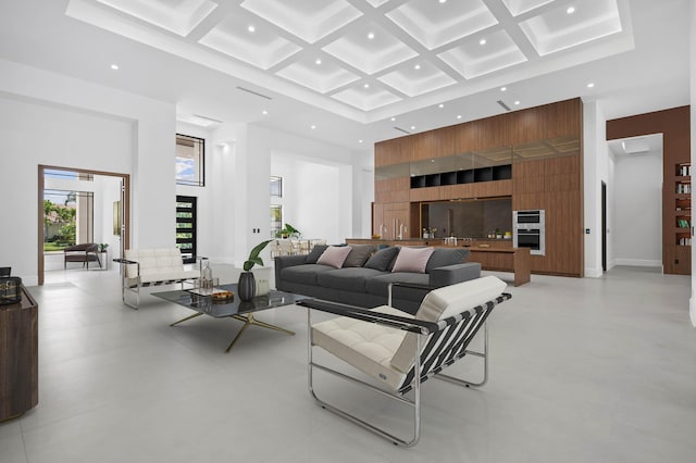 living room featuring a high ceiling, coffered ceiling, and beam ceiling