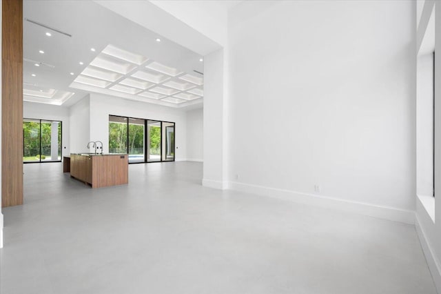 spare room featuring coffered ceiling, a towering ceiling, and beamed ceiling