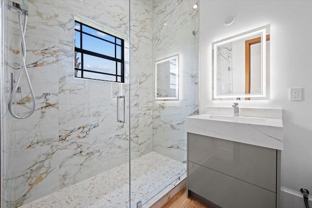 bathroom featuring a shower with door, vanity, and wood-type flooring