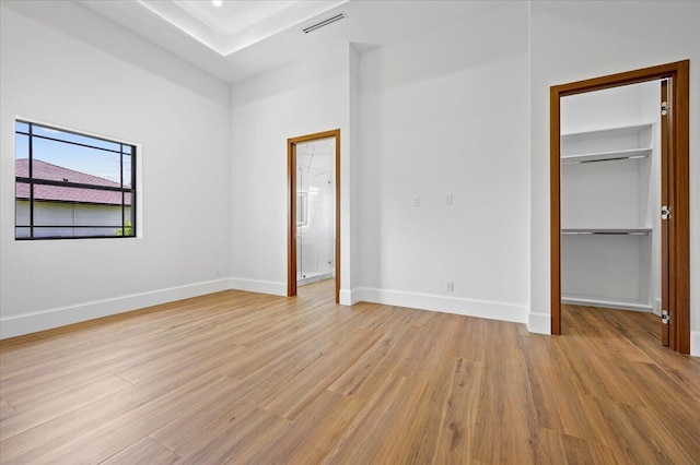 unfurnished bedroom featuring light hardwood / wood-style flooring and connected bathroom