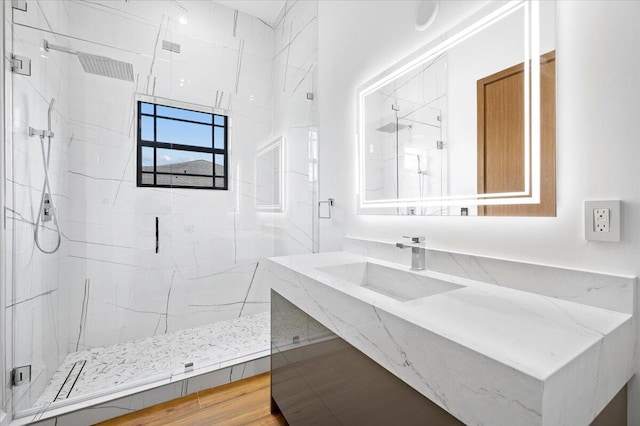 bathroom featuring sink, an enclosed shower, and hardwood / wood-style flooring