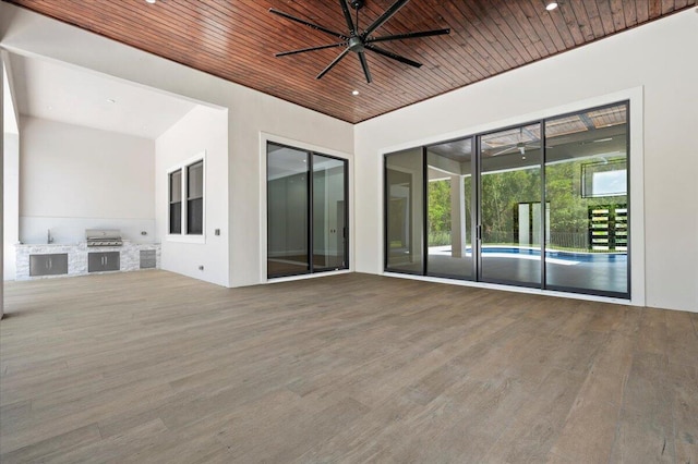 interior space with an outdoor kitchen, ceiling fan, and a grill