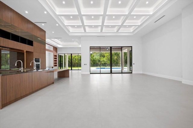 interior space featuring a towering ceiling, beamed ceiling, and coffered ceiling