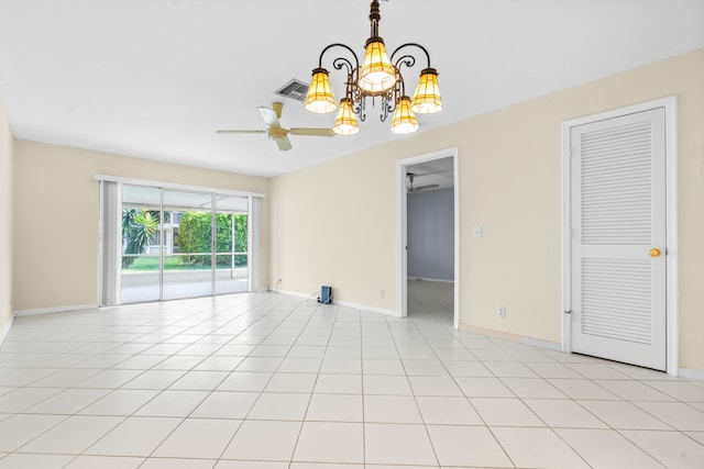 spare room featuring light tile patterned floors and ceiling fan with notable chandelier