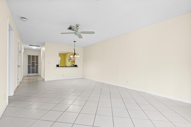 unfurnished living room featuring light tile patterned flooring and ceiling fan with notable chandelier