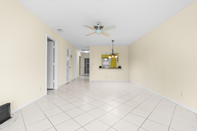 spare room with light tile patterned flooring and ceiling fan with notable chandelier