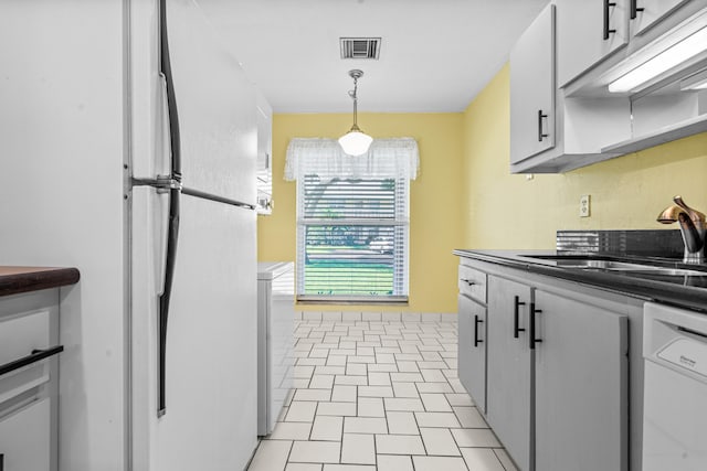 kitchen with pendant lighting, white appliances, white cabinetry, and sink