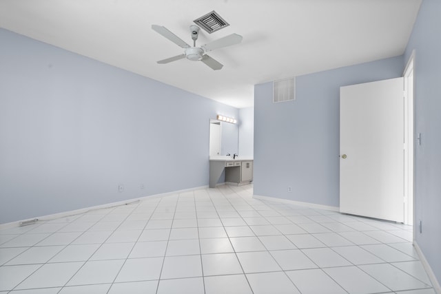 spare room with ceiling fan, light tile patterned flooring, and built in desk