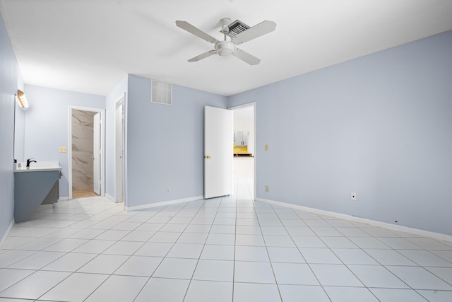 spare room featuring light tile patterned floors, ceiling fan, and sink