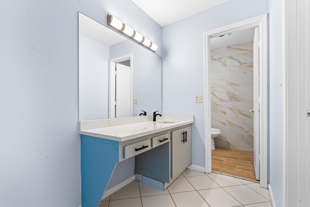 bathroom with tile patterned flooring, vanity, and toilet