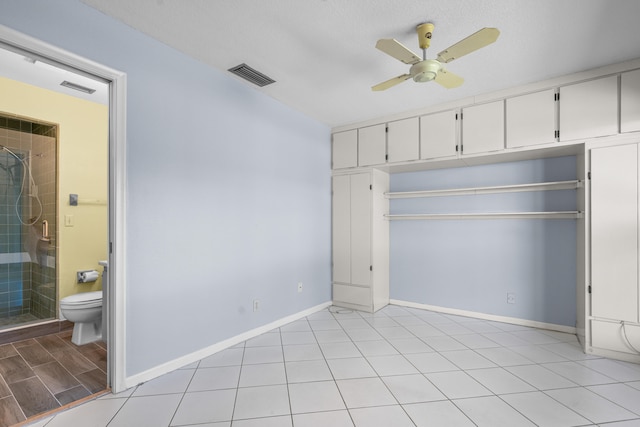 unfurnished bedroom with a textured ceiling, connected bathroom, a closet, and ceiling fan