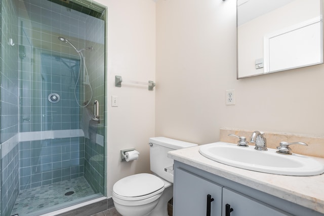 bathroom with vanity, a shower with shower door, and toilet