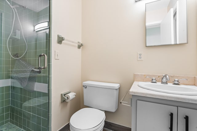 bathroom featuring hardwood / wood-style flooring, vanity, toilet, and a shower with shower door