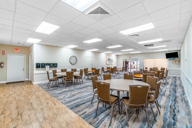 dining area featuring hardwood / wood-style floors and a paneled ceiling