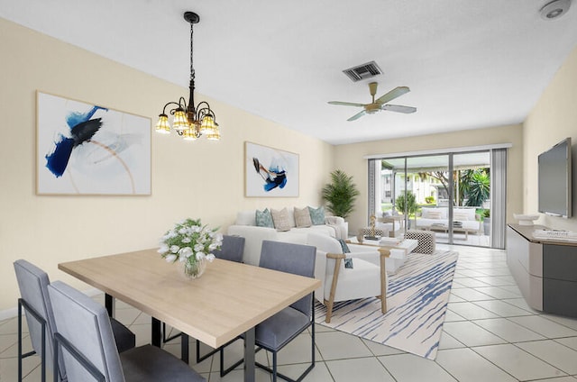 tiled dining room featuring ceiling fan with notable chandelier