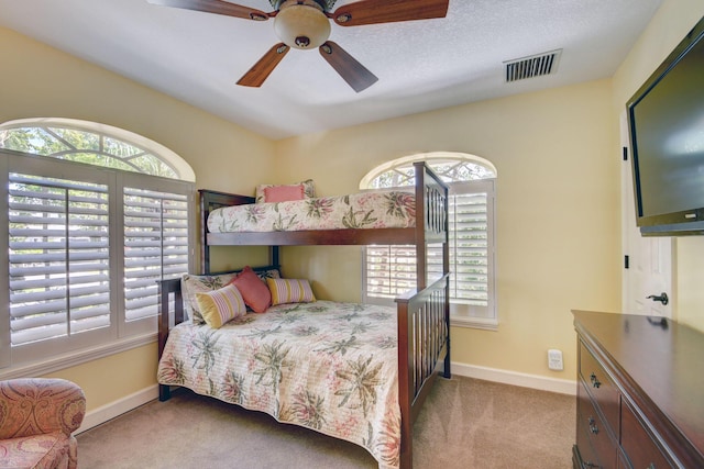 carpeted bedroom with a textured ceiling and ceiling fan