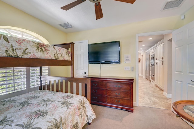 carpeted bedroom with ceiling fan and a textured ceiling