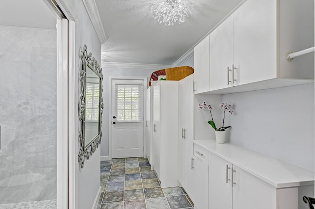 interior space with a chandelier, a textured ceiling, and ornamental molding