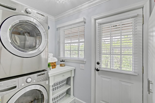 clothes washing area with crown molding, stacked washing maching and dryer, a textured ceiling, and a wealth of natural light