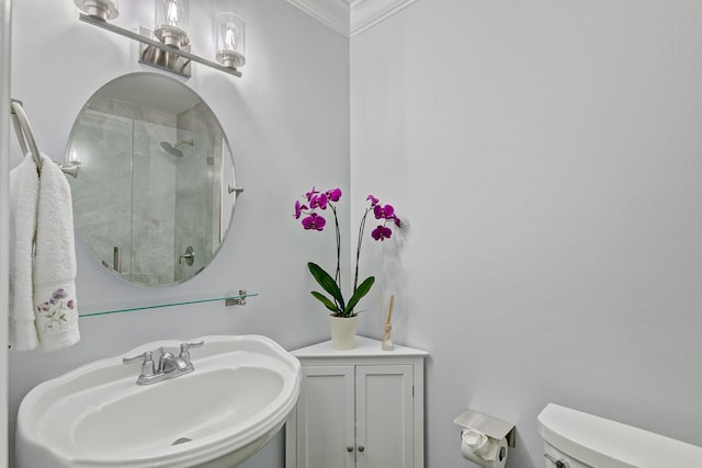 bathroom with an enclosed shower, toilet, crown molding, and sink