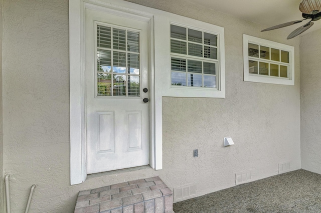 doorway to property with ceiling fan