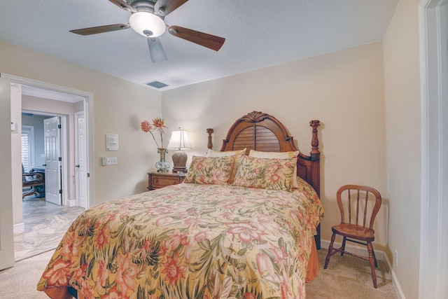 carpeted bedroom featuring ceiling fan and a textured ceiling