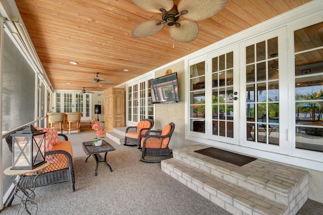 sunroom featuring ceiling fan and wooden ceiling