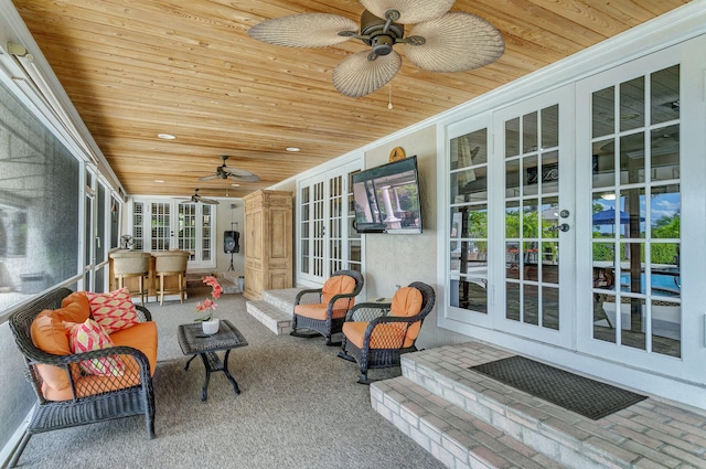 sunroom / solarium with ceiling fan and wood ceiling