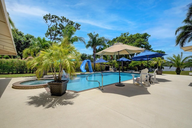 view of pool featuring a patio area, an in ground hot tub, and a water slide