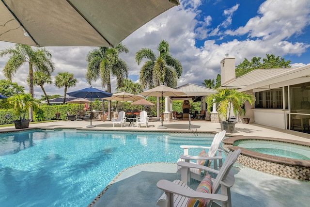 view of pool with a patio area and an in ground hot tub