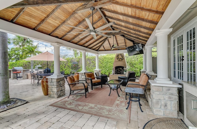 view of patio / terrace with a gazebo, ceiling fan, french doors, and exterior fireplace