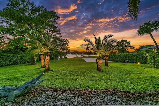 yard at dusk featuring a water view