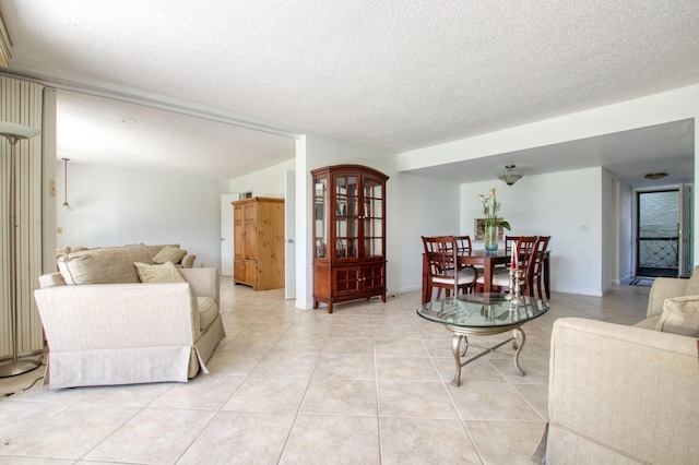 tiled living room featuring a textured ceiling