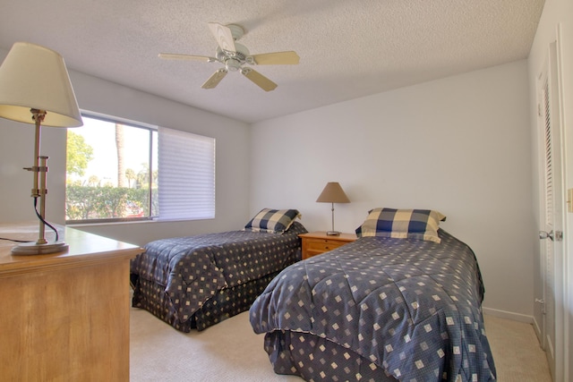 carpeted bedroom featuring a textured ceiling and ceiling fan