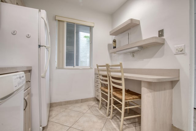 kitchen with light tile patterned flooring and washer / dryer