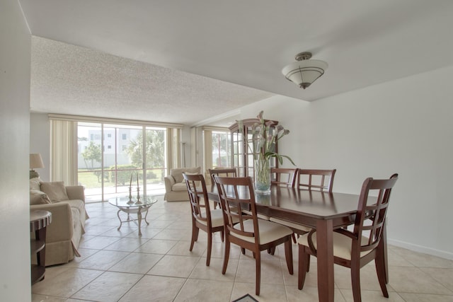 dining space with expansive windows, light tile patterned floors, and a textured ceiling