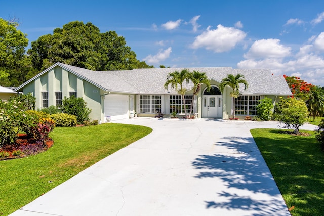 ranch-style house featuring a front yard and a garage