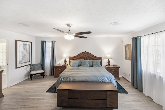 bedroom featuring ceiling fan, light hardwood / wood-style floors, and a textured ceiling