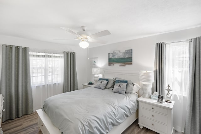 bedroom with dark hardwood / wood-style floors and ceiling fan