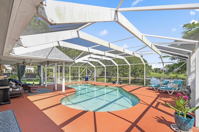 view of swimming pool with a patio, a water view, and a lanai