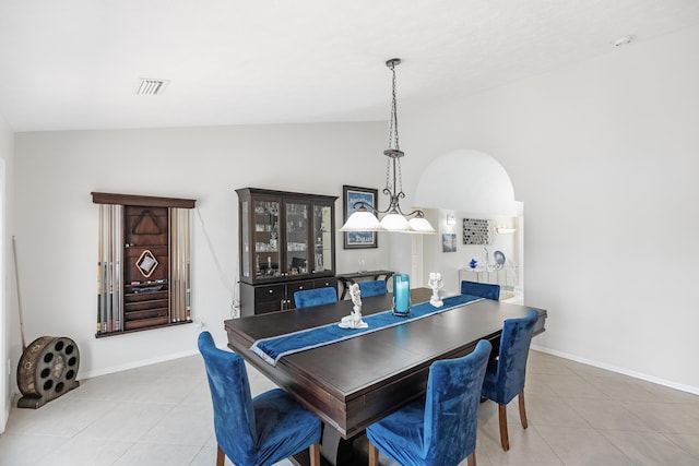 tiled dining room featuring lofted ceiling