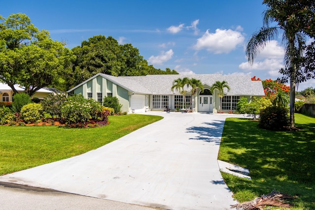 ranch-style home featuring a garage and a front lawn