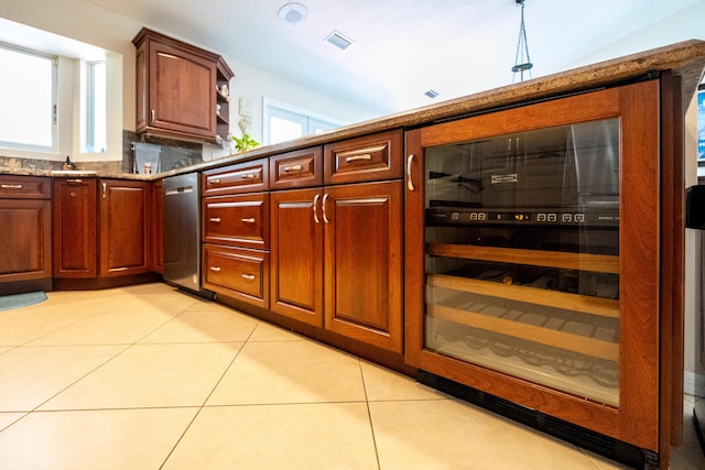 kitchen with dishwasher, light tile patterned floors, plenty of natural light, and beverage cooler