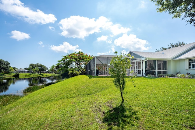 view of yard with a water view and glass enclosure