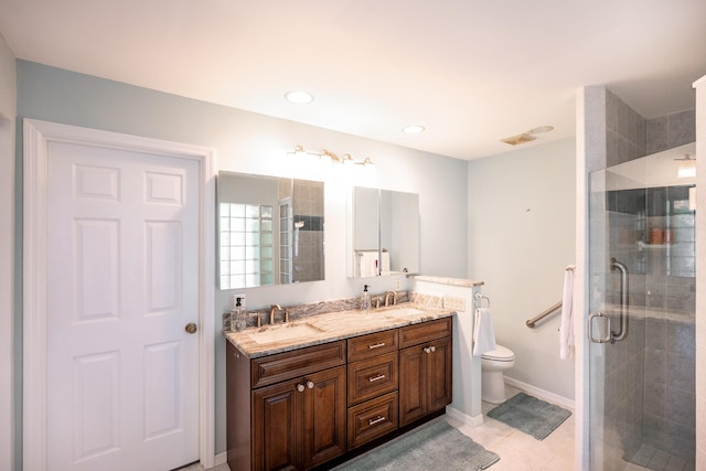 bathroom featuring tile patterned flooring, vanity, toilet, and a shower with door