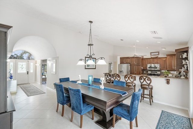 dining space with vaulted ceiling and light tile patterned flooring