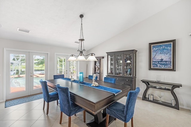 dining space featuring french doors, light tile patterned flooring, and vaulted ceiling