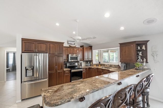 kitchen featuring kitchen peninsula, appliances with stainless steel finishes, backsplash, and sink